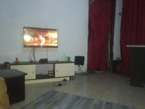 a living room with a flat screen tv on a tv stand at Urban-den in Kampala