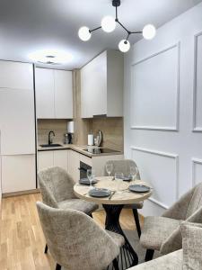 a living room with a table and chairs and a kitchen at Tiffany Delux in Banja Luka