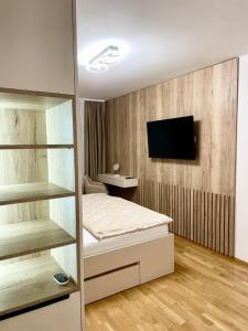 a bedroom with a bed and a tv on a wall at Tiffany Delux in Banja Luka