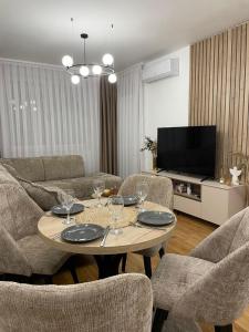 a living room with a table and chairs and a television at Tiffany Delux in Banja Luka