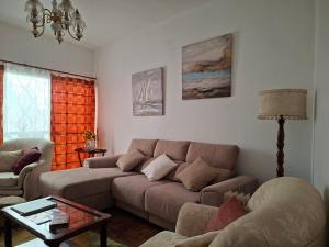 a living room with a couch and a table at Casa das Floreiras - City Center Apartment in Horta +1 photo