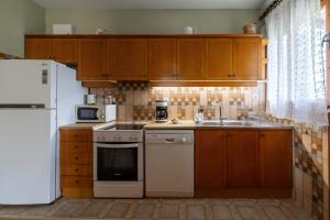 a kitchen with wooden cabinets and a white appliance at Ioanna Sunset Retreat in Chalkida