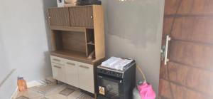 a small kitchen with a stove and a cabinet at Rancho citrus in Coruripe