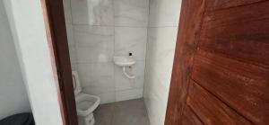 a small bathroom with a toilet and a sink at Rancho citrus in Coruripe