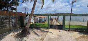 a playground next to a palm tree next to the water at Rancho citrus in Coruripe