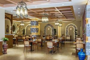 a restaurant with tables and chairs and chandeliers at Farovon Tashkent Boutique Hotel in Tashkent