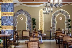 a restaurant with arches and tables and chairs at Farovon Tashkent Boutique Hotel in Tashkent +25 photos