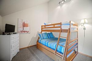 a bedroom with a bunk bed and a desk with a television at 28 Quelah Condo in Sunriver +24 photos