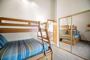 a bedroom with two bunk beds and a mirror at 28 Quelah Condo in Sunriver