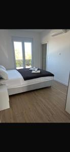 a large bed in a room with two windows at Rados Villa Flora in Fažana