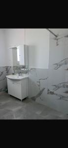 a white bathroom with a sink and a mirror at Rados Villa Flora in Fažana