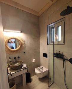 ein Badezimmer mit Waschbecken, Toilette und Spiegel in der Unterkunft Arokaria Studios in Gaios