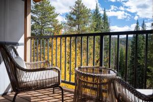 two chairs on a balcony with a view of trees at Beaver Village Unit #2031 in Winter Park