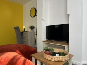 a living room with a television and a table with plants at Two Bedroom Flat Bristol in Shirehampton