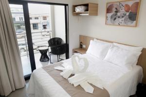 a hotel room with a bed with a towel on it at Hotel Jaiba Premium in Terra Fôfa