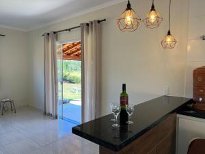 a kitchen with two glasses of wine on a counter at Mar Azul in Espirito Santo Do Pinhal
