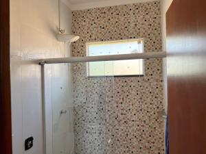 a bathroom with a shower with a window at Mar Azul in Espirito Santo Do Pinhal