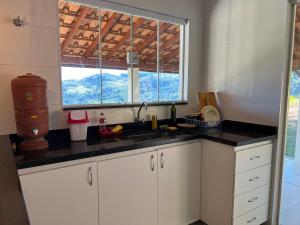 a kitchen with a sink and a window at Mar Azul in Espirito Santo Do Pinhal +58 photos