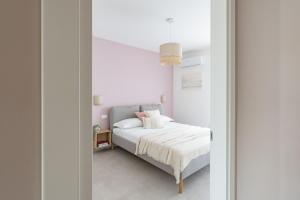 a bedroom with a bed with white sheets and pink pillows at Villa Novelli - YourPlace Abruzzo in Fossacesia