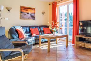 a living room with a couch and a tv at Ferienhaus Sandra in Wohlenberg
