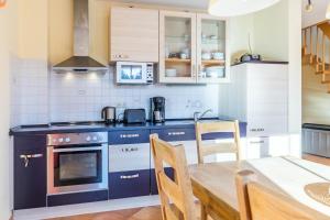 a kitchen with blue cabinets and a table with chairs at Ferienhaus Sandra in Wohlenberg +17 photos