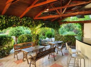 a patio with tables and chairs and vines at Penzion Lea in Diakovce