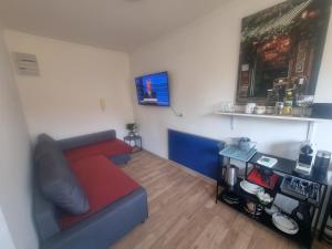 a living room with a red couch and a table at Rax-Basecamp 24 in Reichenau