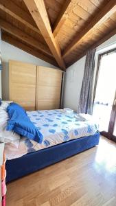 a bedroom with a bed with a blue comforter at Casa Candiotty Lake & Mountain in Endine Gaiano