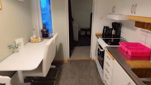 a small kitchen with white cabinets and a sink at Station Stay Örebro in Örebro