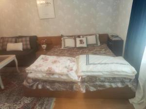 a small bedroom with a bed and a couch at Station Stay Örebro in Örebro