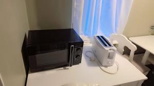 a microwave sitting on top of a table with a tv at Station Stay Örebro in Örebro