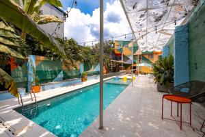 a swimming pool with a red chair next to a building at Medellinn The Blooming Hotel in Medellín