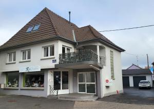 a white building with a balcony on top of it at Le Clocher, nice warm and comfortable nest in Sierentz