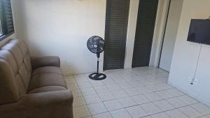 a living room with a couch and a fan at Apartamento Simples em Teresina com 02 Quartos in Teresina +15 photos