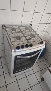 a stove top oven sitting on a tiled kitchen floor at Apartamento Simples em Teresina com 02 Quartos in Teresina