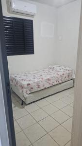 a bed sitting in a room with a white wall at Apartamento Simples em Teresina com 02 Quartos in Teresina