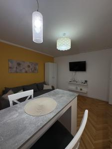 a kitchen and living room with a table and a couch at City Vibes in Subotica
