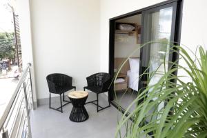a balcony with three chairs and a table at Hotel Jaiba Premium in Terra Fôfa