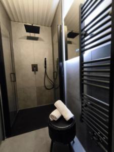 a bathroom with a shower and a stool with a towel at Ferienwohnung Burgperle Burghausen nahe weltlängster Burg zentral 24h Check in in Burghausen