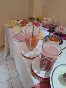 a table with plates of food and drinks on it at Pousada Em-Cantto in Conservatória