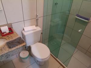 a bathroom with a toilet and a glass shower at Pousada Em-Cantto in Conservatória