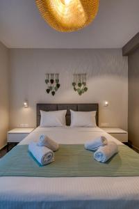 a bedroom with a large bed with towels on it at MARTINI APARTMENTs in Nikiti +13 photos