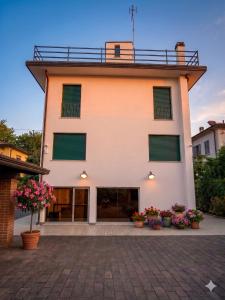 a building with green shuttered windows and potted plants at Villa alle Mura in Lucca