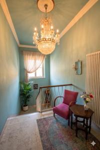 a living room with a chandelier and a chair at Villa alle Mura in Lucca