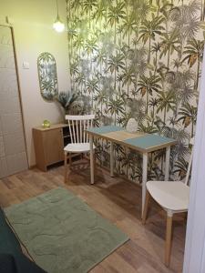 a table and chairs in a room with a wallpaper at Rajca Room's - Pokoje przy Jasnej Górze in Częstochowa