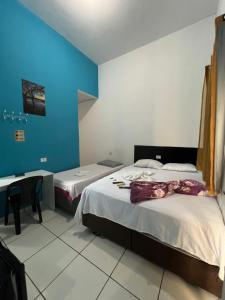 a room with two beds and a desk in it at Pousada Paraiso in Canudos