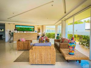 a living room with couches and chairs and a television at Hotel Palmeras De Luz in Moniquirá