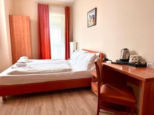 a bedroom with a bed with a desk and a window at Hotel Cavallino s'Rössl in Merano +37 photos