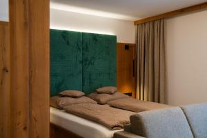 a bedroom with a bed with a green headboard at Zenger Hotel in Offenberg