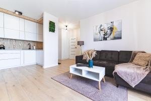 a living room with a couch and a table at Apartament Pirat in Ostróda